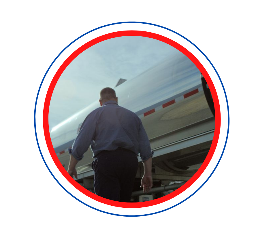 Andrews Logistics driver walking alongside a stainless steel tank trailer